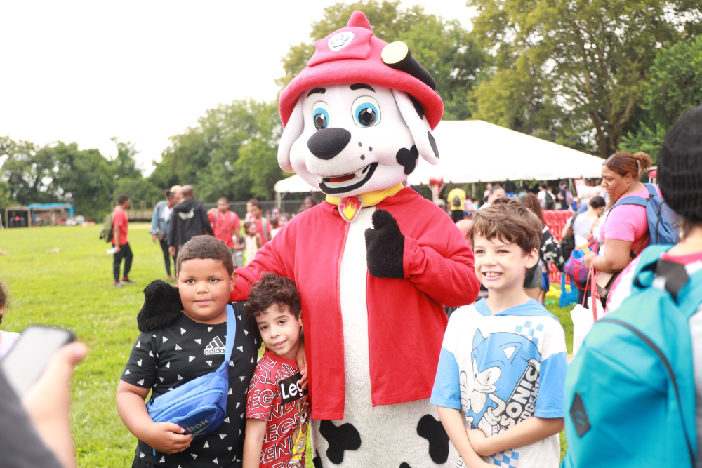 Image of three children with dog mascot