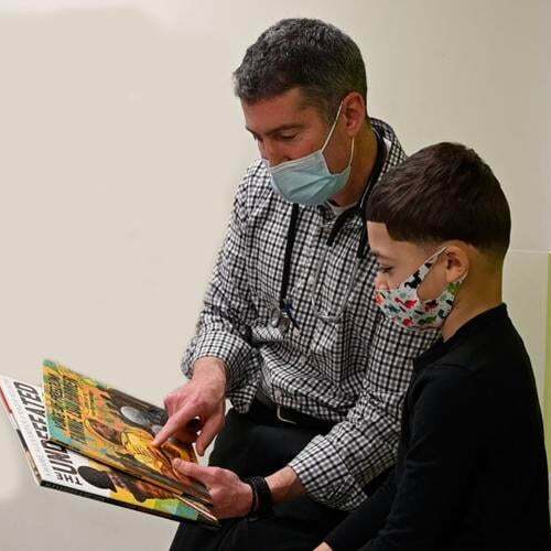 Image of Dr. Dan Taylor reading a book to a child
